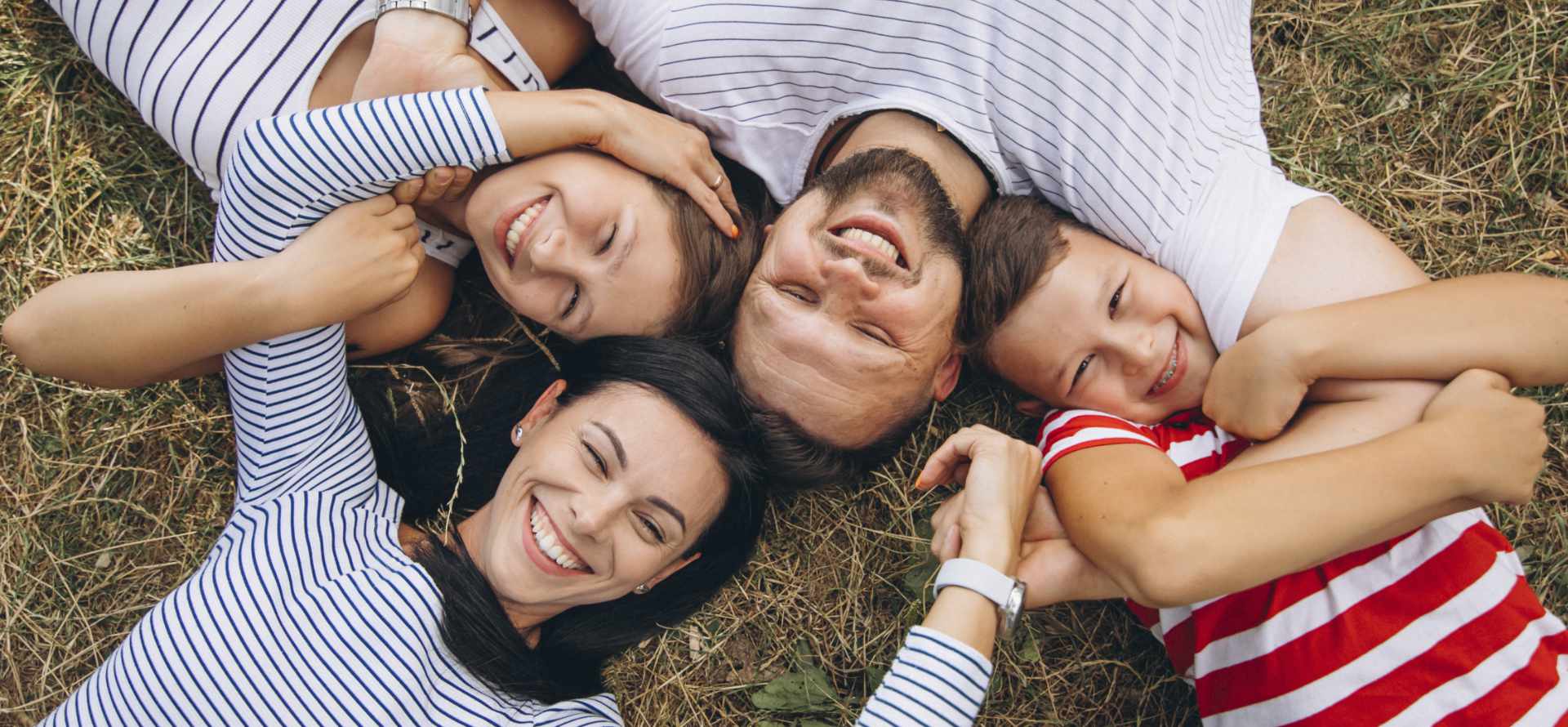 Familia sonriente disfrutando un momento juntos - Umana Consultoría Familiar